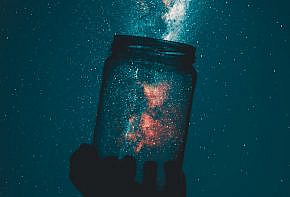 silhouette of person holding glass mason jar